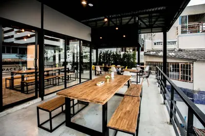 a patio with a wooden table and benches at the CAPSULE by UnionSPACE in Bangkok