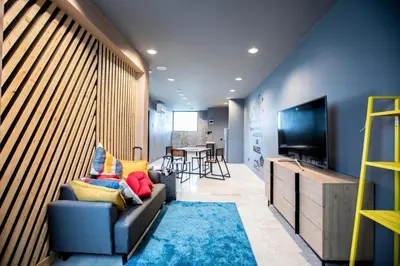 a living room with a couch and a television at the CAPSULE by UnionSPACE in Bangkok