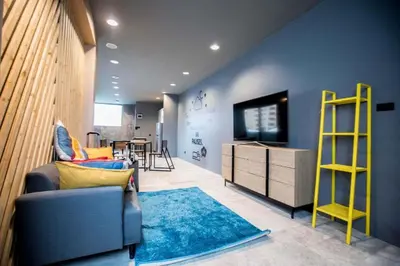 a living room with a couch and a television at the CAPSULE by UnionSPACE in Bangkok