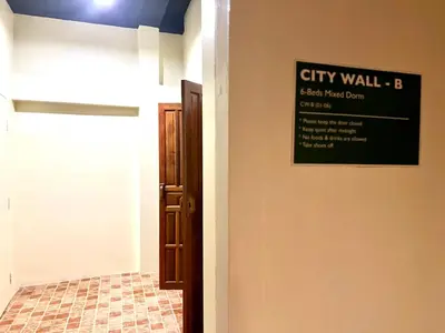 a sign on the wall of a city hallway at Suneta Hostel Khaosan in Bangkok