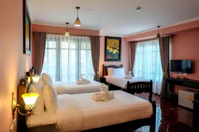 a hotel room with two beds and a television at Siri Heritage Bangkok Hotel in Bangkok