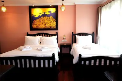 two beds in a room with pink walls at Siri Heritage Bangkok Hotel in Bangkok