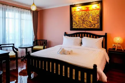a bedroom with a bed with a teddy bear on it at Siri Heritage Bangkok Hotel in Bangkok