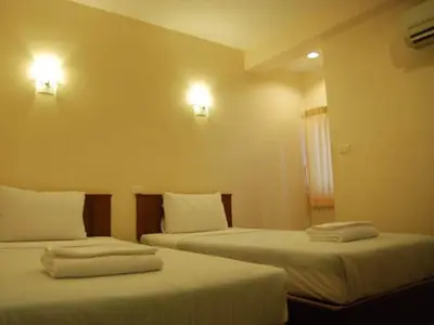 two beds in a hotel room with towels on them at Rambuttri House in Bangkok