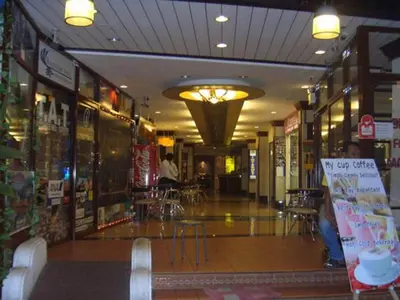 a store hallway with tables and chairs in a building at Rambuttri House in Bangkok