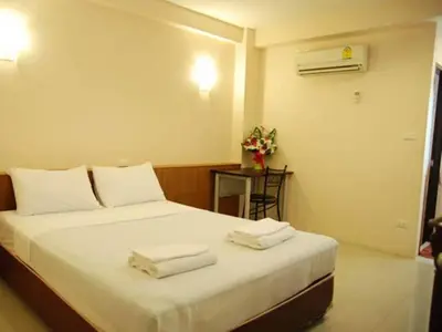 a bedroom with a bed with towels on it at Rambuttri House in Bangkok