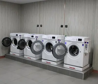 a row of washing machines on a counter in a room at Grand Tower Inn Rama 6 in Bangkok