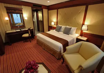 a hotel room with a bed and a chair at Grand Tower Inn Rama 6 in Bangkok
