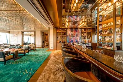 a bar with tables and chairs in a restaurant at Hyatt Regency Bangkok Sukhumvit in Bangkok