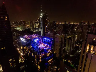 a city skyline at night with blue lights on a building at Hyatt Regency Bangkok Sukhumvit in Bangkok