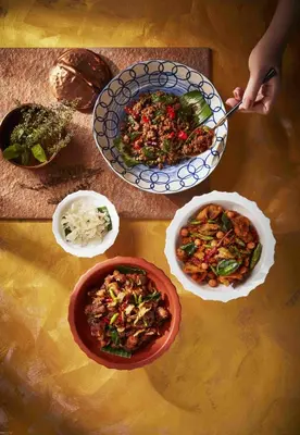 a table with plates of food and bowls of food at Hyatt Regency Bangkok Sukhumvit in Bangkok