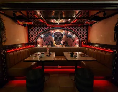 a restaurant with two tables and a skull mural at La Petite Salil Sukhumvit 11 in Bangkok