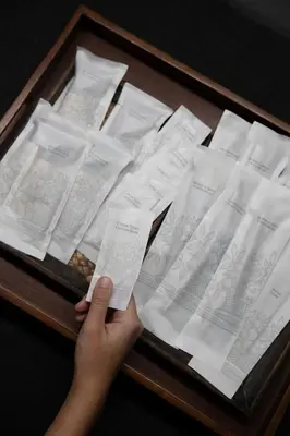 a person holding a box of white envelopes at Nantra Sukhumvit 39 in Bangkok
