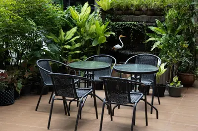 a group of tables and chairs in a garden at Nantra Sukhumvit 39 in Bangkok
