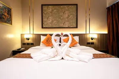 a bed with two white towels in the shape of a heart at Baan Sukhumvit Soi 20 in Bangkok