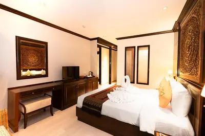 a bedroom with a bed and a desk and a television at Baan Sukhumvit Soi 18 in Bangkok