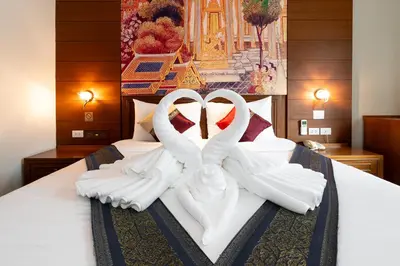 a bedroom with a bed with two white towels at Baan Sukhumvit Soi 18 in Bangkok