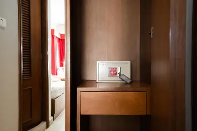 a small clock on a wooden table in a room at Baan Sukhumvit Soi 18 in Bangkok