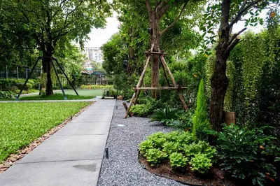 a garden with a wooden stand next to a tree at TK Palace Hotel & Convention Bangkok in Bangkok