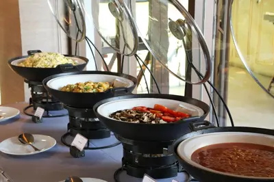 a row of bowls of food on a table at Riva Surya Bangkok in Bangkok