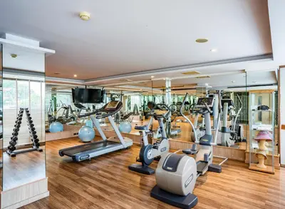 a gym with treadmills and elliptical machines at Riva Surya Bangkok in Bangkok