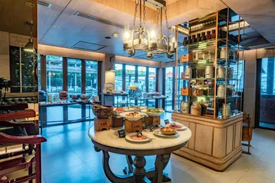 a restaurant with a table with plates of food on it at Riva Surya Bangkok in Bangkok