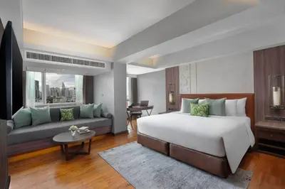 a hotel room with a bed and a couch at Hotel Mermaid Bangkok in Bangkok