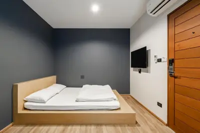 a bedroom with a bed and a tv on a wall at 19A Bangkok in Bangkok