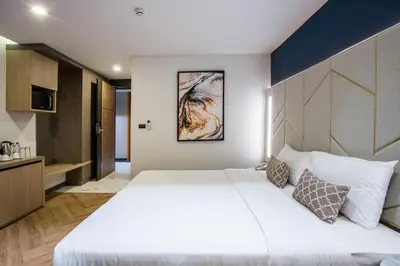 a bedroom with a large white bed and a wall at D Varee Montara Thonglor 25 in Bangkok