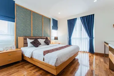 a bedroom with a large bed with blue curtains at D Varee Montara Thonglor 25 in Bangkok
