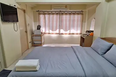 a bedroom with a blue bed and a window at MS Mansion in Bangkok