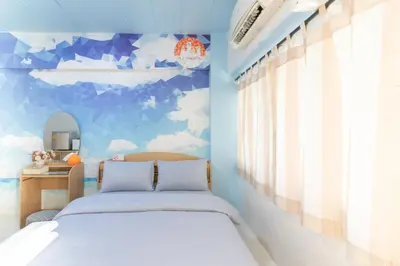 a bedroom with a bed and a blue sky and clouds mural at MS Mansion in Bangkok
