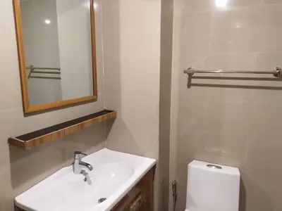 a bathroom with a sink and a mirror and a toilet at Roseate Bangkok Hotel in Bangkok