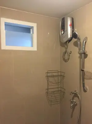 a shower in a bathroom with a window at Roseate Bangkok Hotel in Bangkok