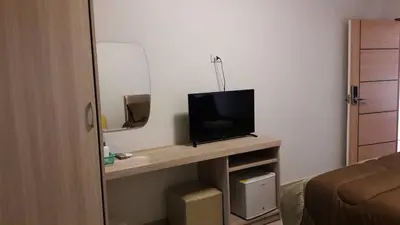 a room with a television on a table in a room at Roseate Bangkok Hotel in Bangkok