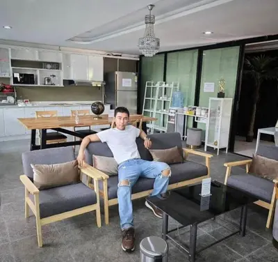a man sitting on a couch in a living room at 51 Suanplu Residence in Bangkok