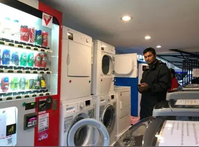 a man is standing next to a washing machine at 51 Suanplu Residence in Bangkok