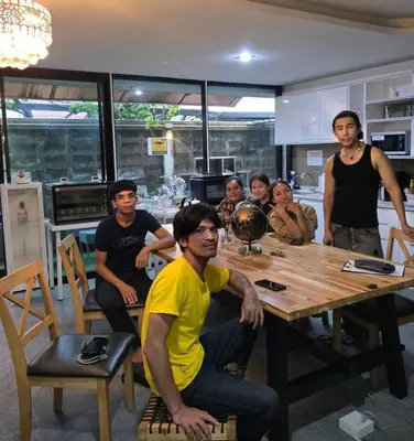 a group of men sitting around a table in a kitchen at 51 Suanplu Residence in Bangkok