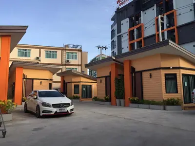 a white car parked in a parking lot in front of buildings at Angie Resort at Sapan Mai in Bangkok