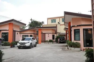 a car parked in a parking lot in front of buildings at Angie Resort at Sapan Mai in Bangkok