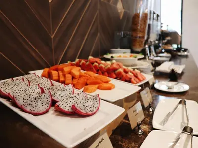 a buffet with a tray of hot dogs and shoes at Zayn Hotel Bangkok - Airport Link Access in Bangkok