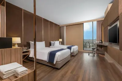 a hotel room with two beds and a television at Zayn Hotel Bangkok - Airport Link Access in Bangkok