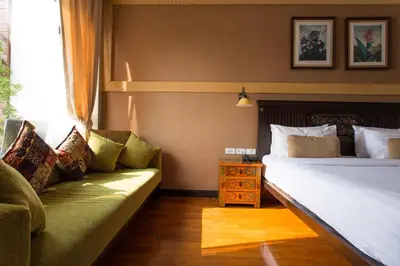 a hotel room with two beds and a couch at Sala Arun in Bangkok