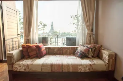 a couch sitting in front of a large window at Sala Arun in Bangkok