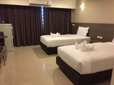 a hotel room with two beds and a table at 14 Resort in Bangkok