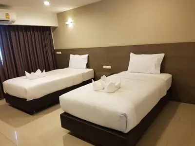 a hotel room with two beds with white pillows at 14 Resort in Bangkok