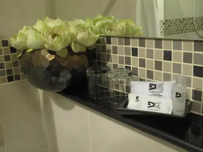 a shelf in a bathroom with a vase of flowers at 14 Resort in Bangkok