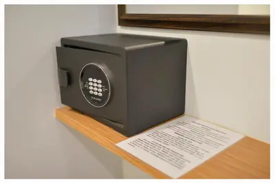 a black microwave sitting on a wooden shelf at 4M Pratunam Hotel in Bangkok