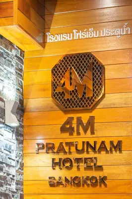 a sign for a hotel on a wooden wall at 4M Pratunam Hotel in Bangkok