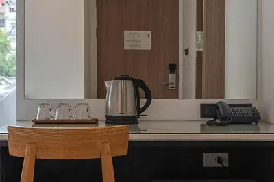 a kitchen counter with a coffee maker and a phone at The Period Pratunam in Bangkok